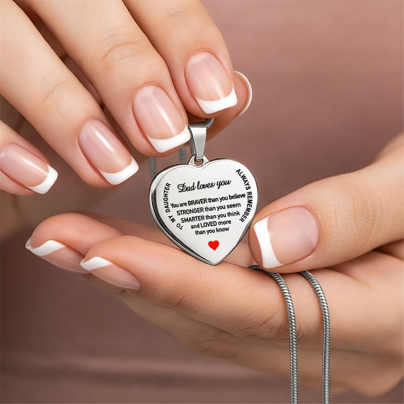 Personalized silver heart pendant necklace engraved with a message to a daughter from dad, held between hands. - Gifts For Family Online