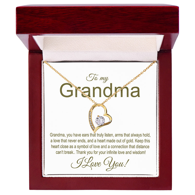 Gold necklace with heart design in a gift box addressed to 'Grandma' with a sentimental message.