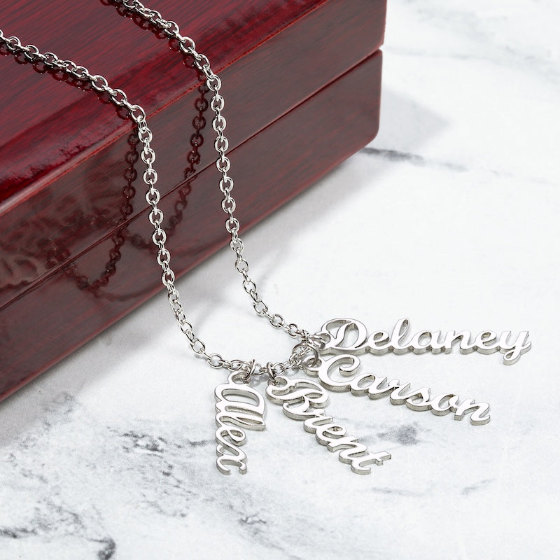 Silver necklace with name charms on a marble surface