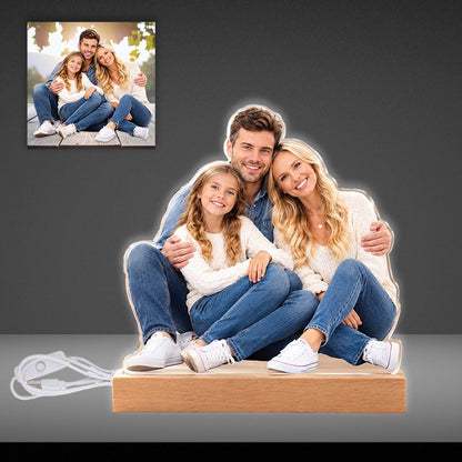 Custom double-sided acrylic family photo cutout plaque mounted on a lit wooden LED base with a dark backdrop.