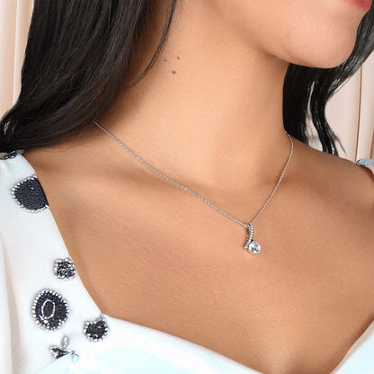 Necklace with a alluring pendant on a model wearing a white top with black patterns.