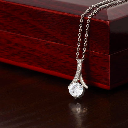 Silver necklace with a zirconia crystal centered pendant on a wooden gift box
