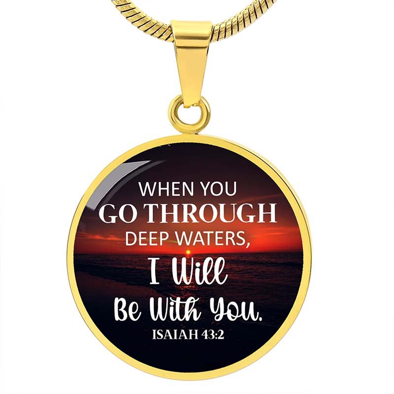 Gold pendant with a sunset design and Bible verse text on a white background
