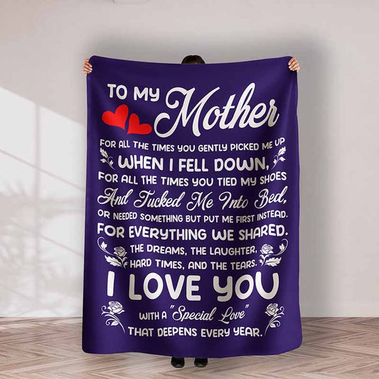 Person holding a purple blanket with a heartfelt message to their mother.
