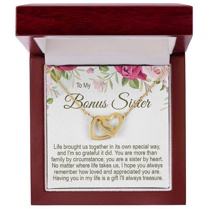 To My Bonus Sister gold interlocking heart necklace in a mahogany-style wooden gift box with a floral message card.   