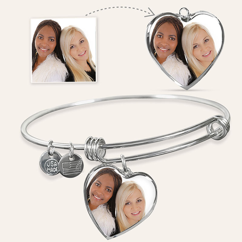 Silver bangle with heart-shaped photo charms featuring two women's faces, inset with a photo of the same women.