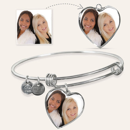 Silver bangle with heart-shaped photo charms featuring two women's faces, inset with a photo of the same women.