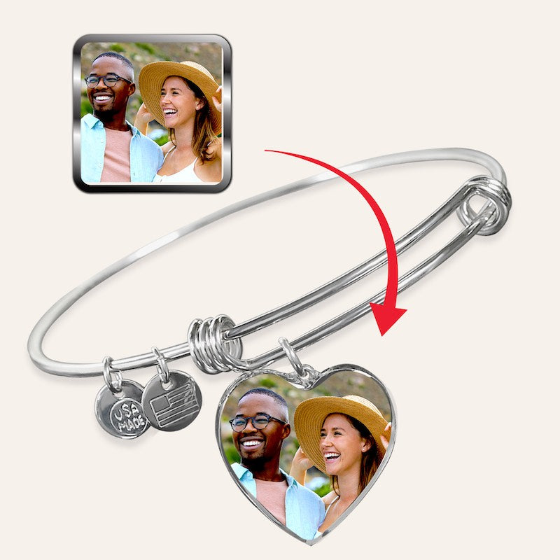 Silver photo bangle bracelet with heart-shaped charm featuring a photo of a couple, inset with the same image.