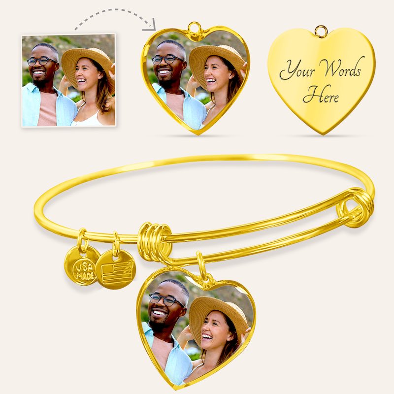 Gold engraved bangle bracelet with heart-shaped charms featuring a couple's photo and 'Your Words Here' text on a light background.