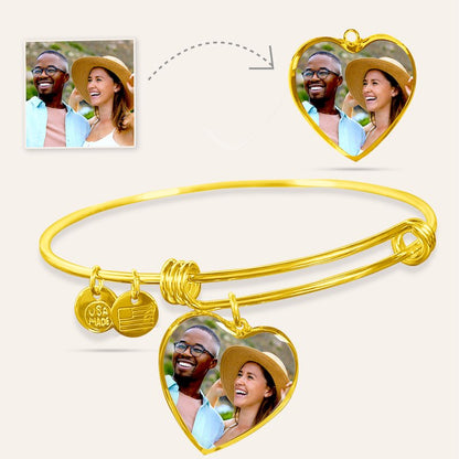 Gold bangle with heart-shaped photo charms featuring a couple, on a light beige background.