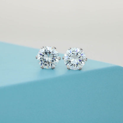 Cubic Zirconia Stud Earrings: Round cubic zirconia stud earrings with silver-tone prong settings displayed on a soft blue surface.