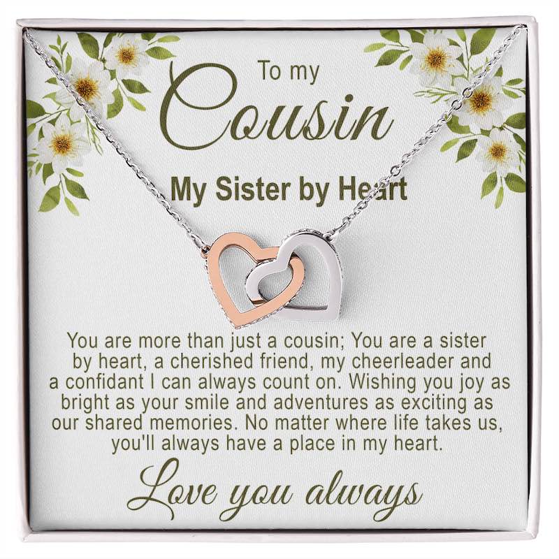 Gifts for cousin: Interlocking rose gold and silver hearts necklace in a white gift box with a white floral cousin message card.