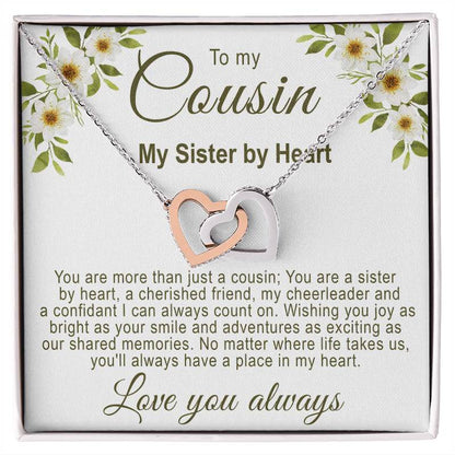 Gifts for cousin: Interlocking rose gold and silver hearts necklace in a white gift box with a white floral cousin message card.