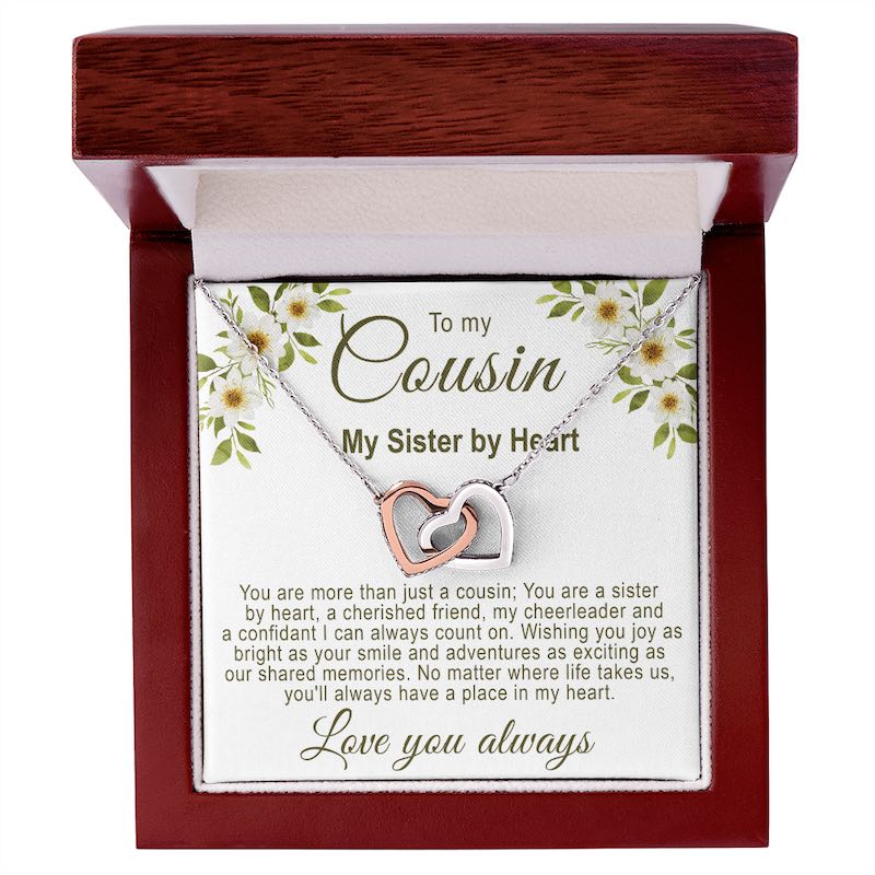 Cousin gift ideas: Interlocking rose gold and silver hearts necklace in a luxury mahogany-style gift box with a white floral cousin message card.