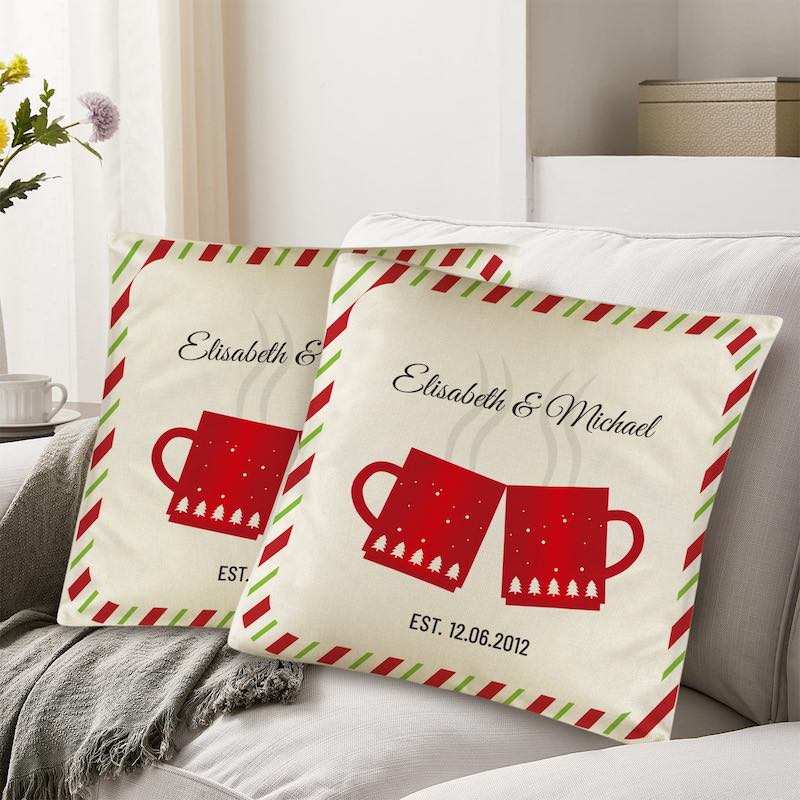 Two decorative pillows with red mugs and personalized text on a couch.