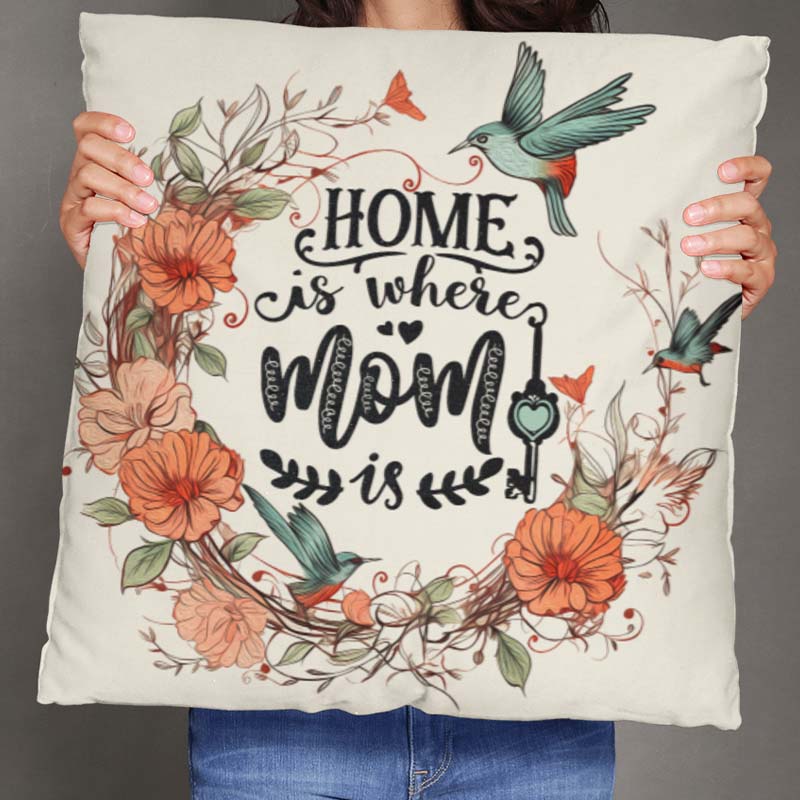 Person holding a decorative custom pillow case with floral design and 'Home is where Mom is' text.