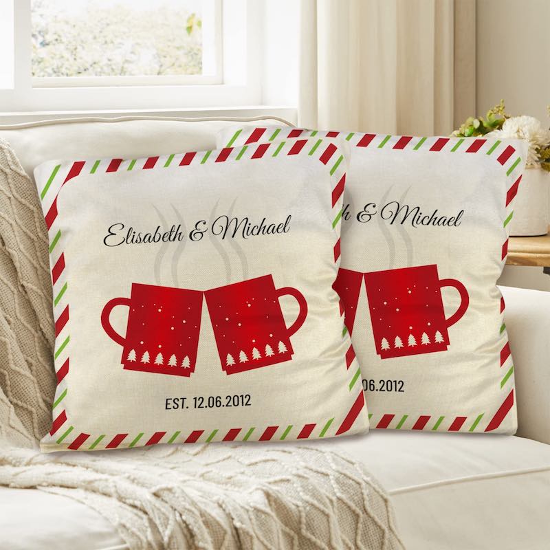 Two decorative pillows with red mugs and personalized text on a couch.