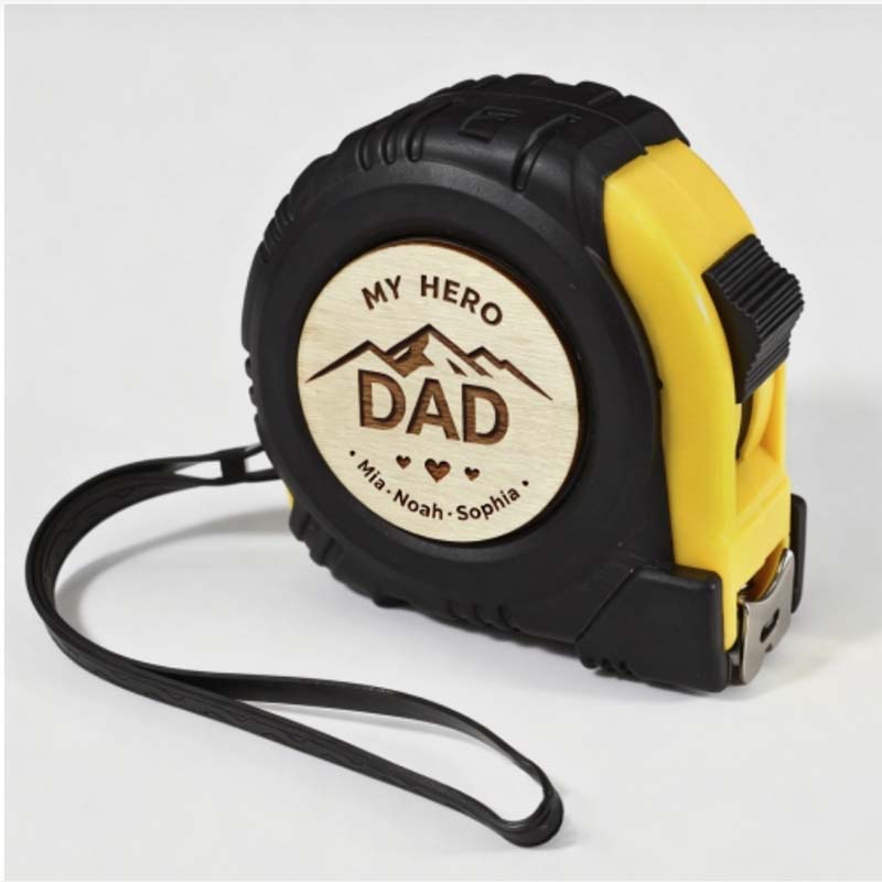 Custom engraved measuring tape featuring a round wooden "My Hero Dad" insert, personalized with names.