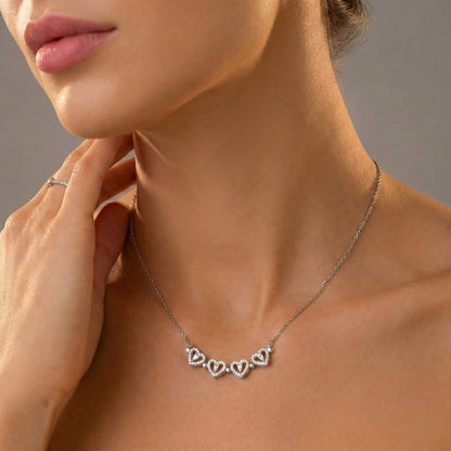Close-up of a woman wearing a silver necklace with heart-shaped pendants.
