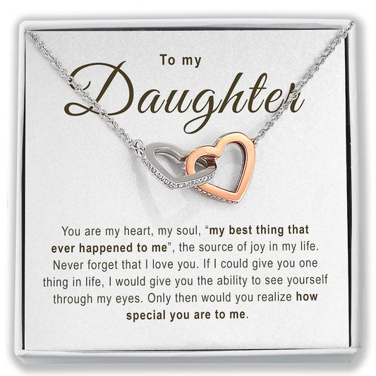 A necklace with two interlocking heart pendants, one rose gold and one silver, displayed on a white gift card that reads 'To my Daughter' with a sentimental message below.