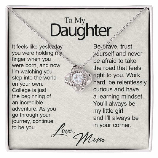 A silver necklace with a heart-shaped crystal pendant displayed on a printed gift card addressed 'To My Daughter' with sentimental text and 'Love, Mom' at the bottom.