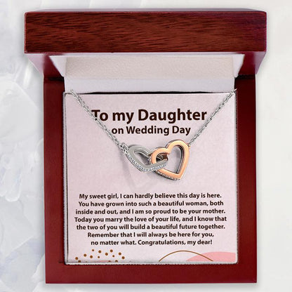 A heart-shaped double necklace with one rose gold heart and one silver heart, presented on a white card with a wedding message inside a dark reddish-brown gift box. The card reads 'To my Daughter on Wedding Day'.