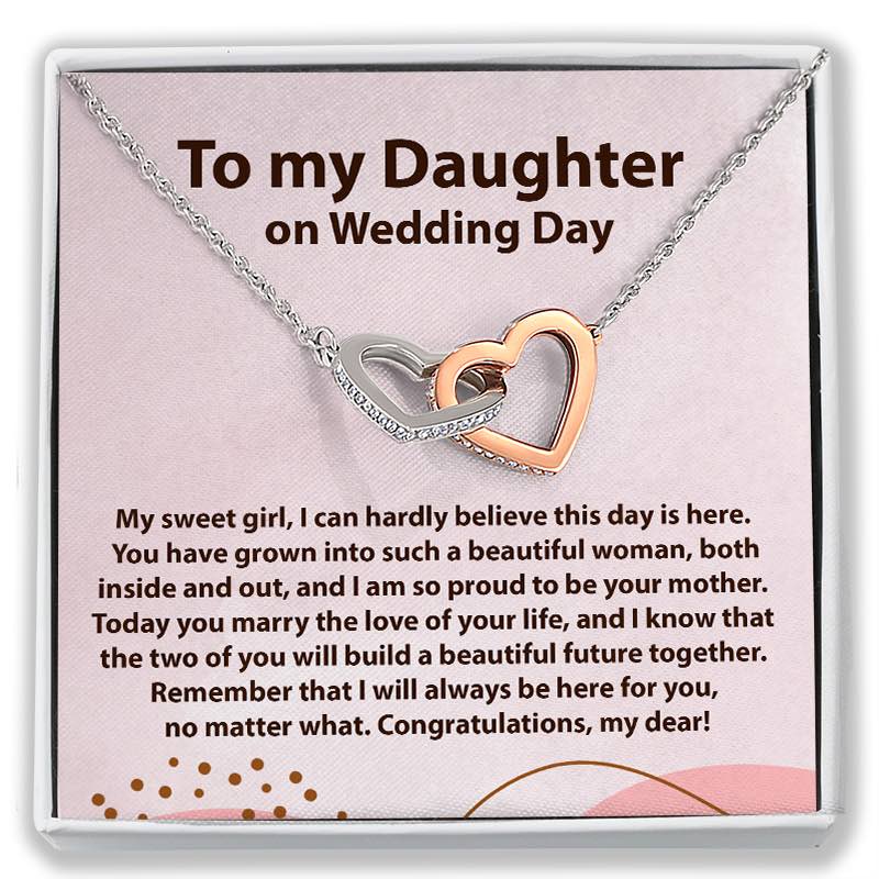 A gift card necklace for a daughter's wedding day, featuring two interlocking heart-shaped pendant links in silver and rose gold, displayed on a pink card with a sentimental message. The card is presented inside a white gift box.