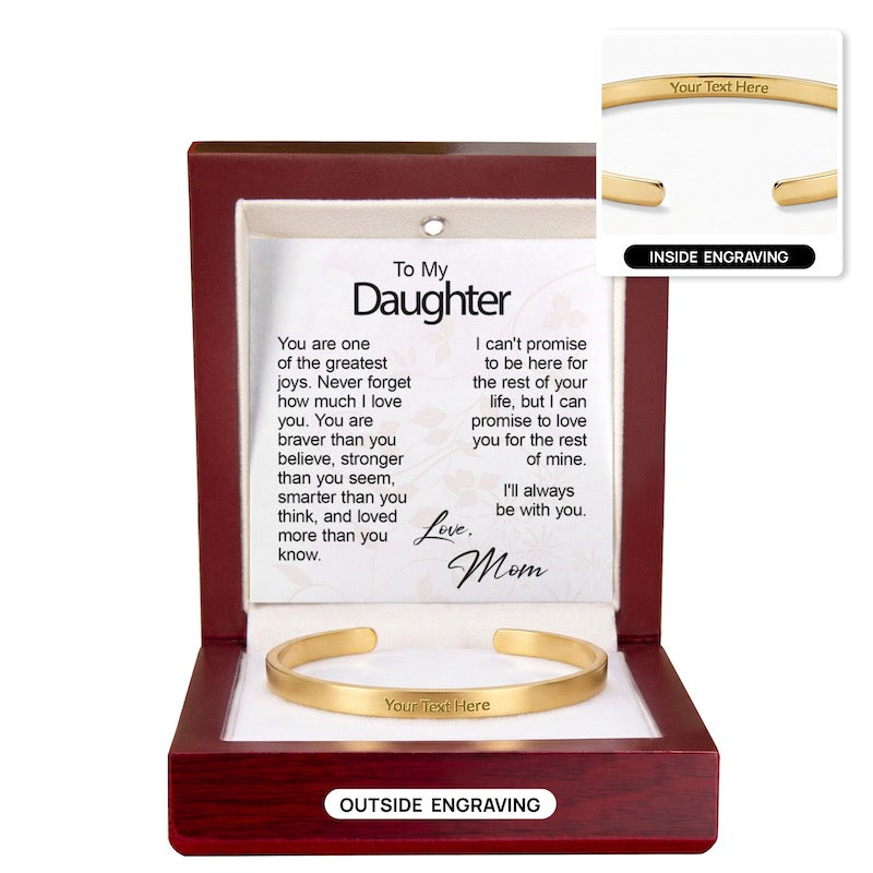 Gold engraved cuff bracelet in an open mahogany wooden gift box with a "To My Daughter" message card from Mom, showing outer engraving on the main bracelet and an inset graphic labeled "Inside Engraving."