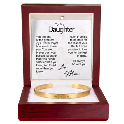 Gold engraved cuff bracelet presented in an open mahogany gift box with an illuminated top interior and a printed "To My Daughter" message card signed "Love, Mom."   