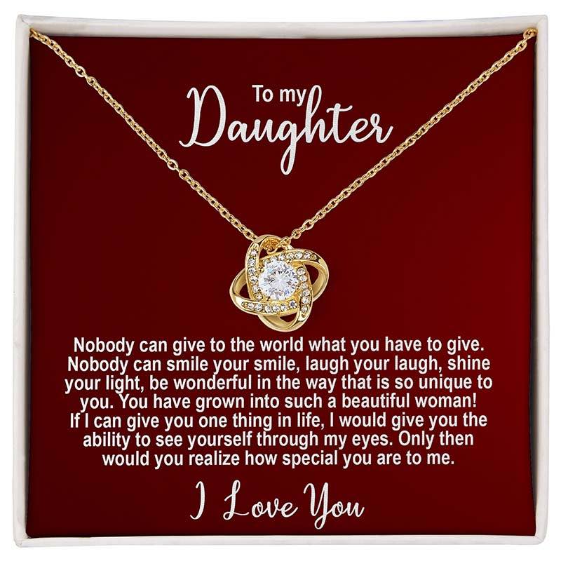 Gold knot necklace in a standard box with personalized message for a daughter on a red card.