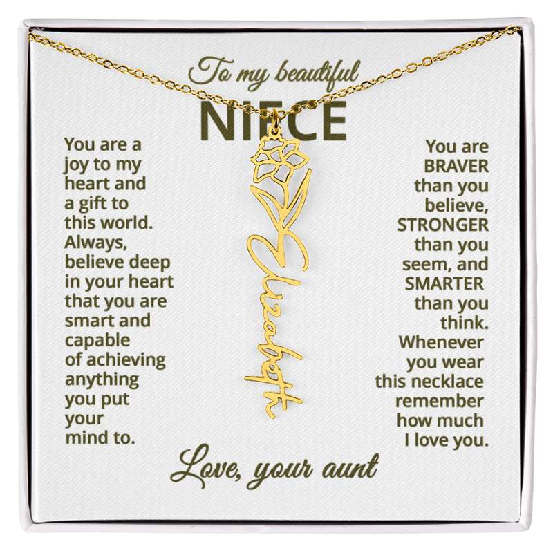 Gold name necklace and narcissus flower pendant on a card with sentimental message for niece on a white background , displayed in a white box.