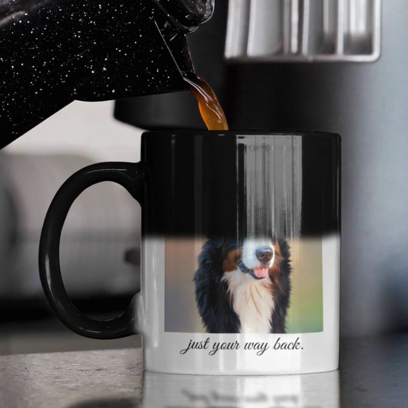 Black mug with a dog design and text, being filled with coffee from an espresso machine.