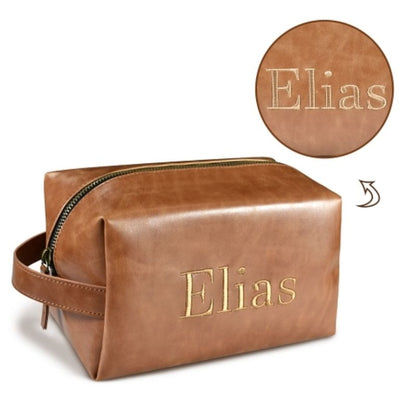 Custom embroidered brown PU leather toiletry bag for men featuring a side handle, zipper closure, and personalized name Elias in gold stitching.