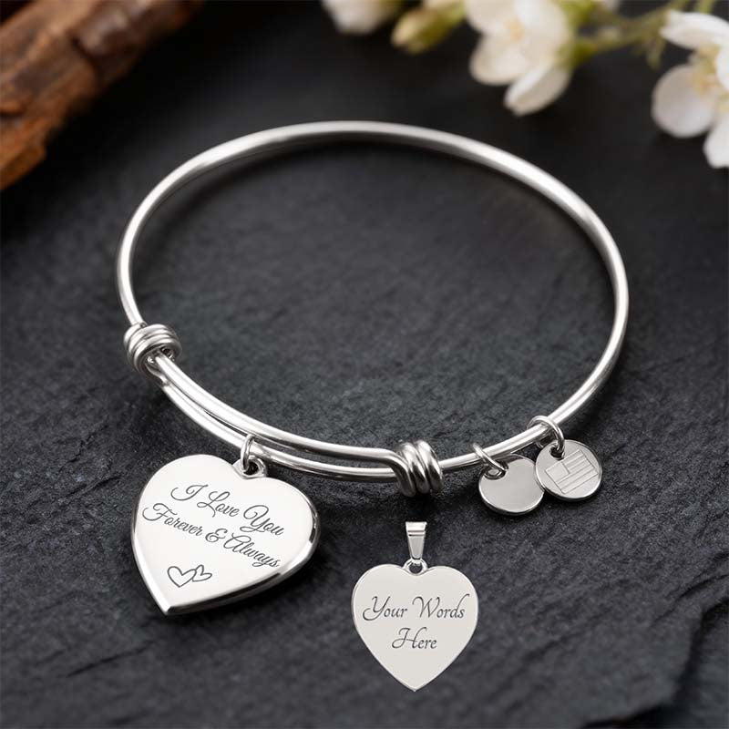 Silver custom bracelet with heart-shaped charms on a dark surface with flowers in the background