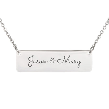A silver rectangular bar necklace with the names 'Jason & Mary' engraved in black cursive script, shown against a plain white background.