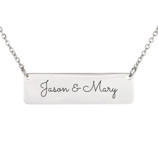 A silver rectangular bar necklace with the names 'Jason & Mary' engraved in black cursive script, shown against a plain white background.