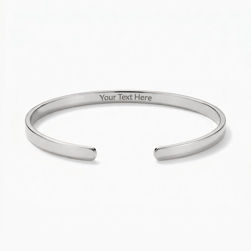 Silver engraved cuff bracelet with sample text reading "Your Text Here" centered on the inside band, displayed on a plain white background.