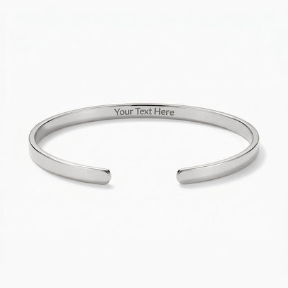 Silver engraved cuff bracelet with sample text reading "Your Text Here" centered on the inside band, displayed on a plain white background.