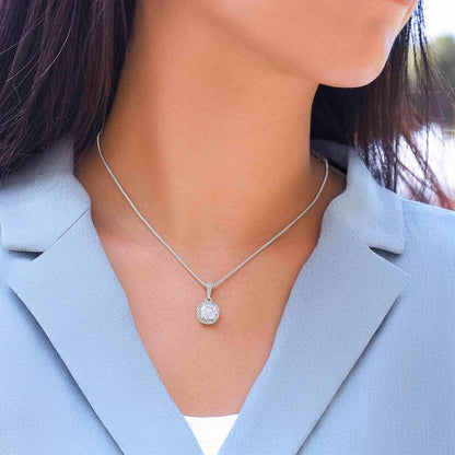 Silver Cubic Zirconia necklace with a round pendant worn by a person in a light blue blazer.