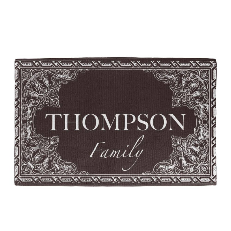 Personalized dark brown doormat customized with your family name, featuring ornate white scrollwork corner designs and border details. - Gifts For Family Online
