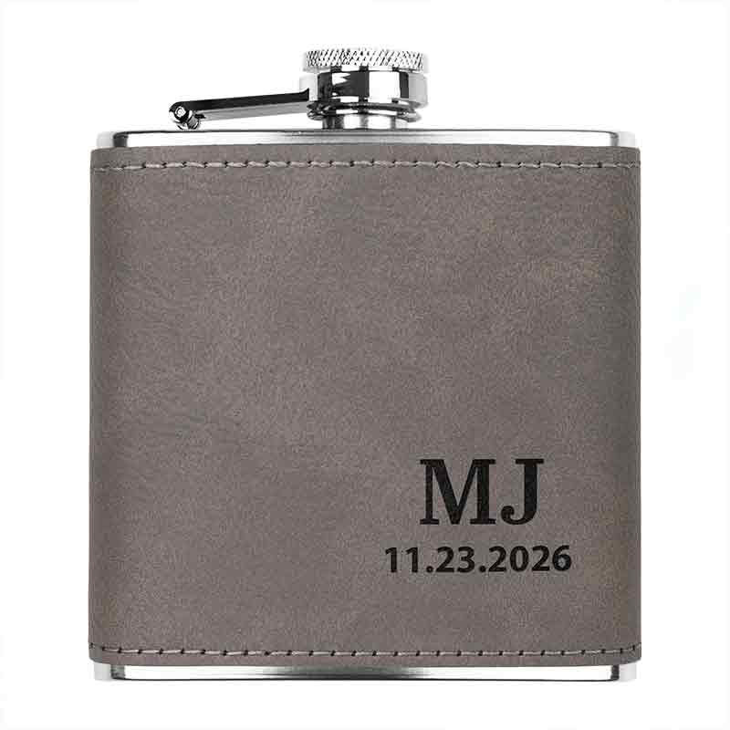 Stainless steel custom engraved flask in  gray color, showing customized initials and date engraving.