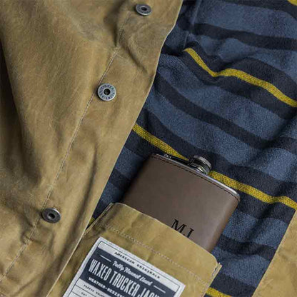 Dark brown custom engraved stainless steel flask tucked inside a light brown jacket pocket.