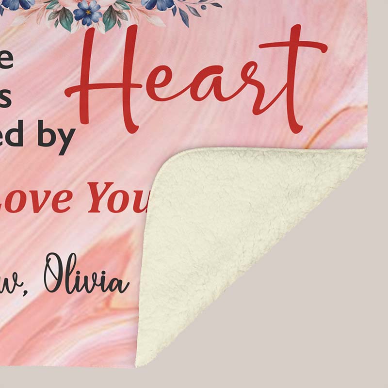 Pink floral-themed blanket with text for grandparents from grandchildren showing the underside white sherpa, on a beige background.