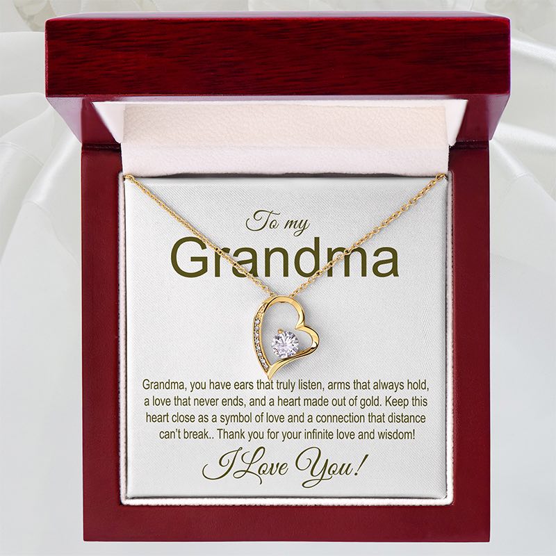 Gold necklace with heart design in a gift box addressed to 'Grandma' with a sentimental message.