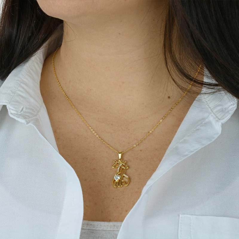 Gold giraffe pendant necklace worn by a woman, delicate chain with crystal accents—elegant gift jewelry for moms