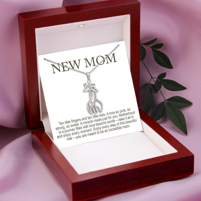 Silver giraffe pendant necklace on chain with “New Mom” message card, displayed in a gift box—meaningful gift for new mothers