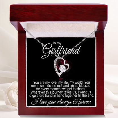 Jewelry for girlfriend: An open luxury mahogany-style gift box displaying a silver heart-shaped necklace with a central crystal and a romantic "To my Girlfriend" message card.   