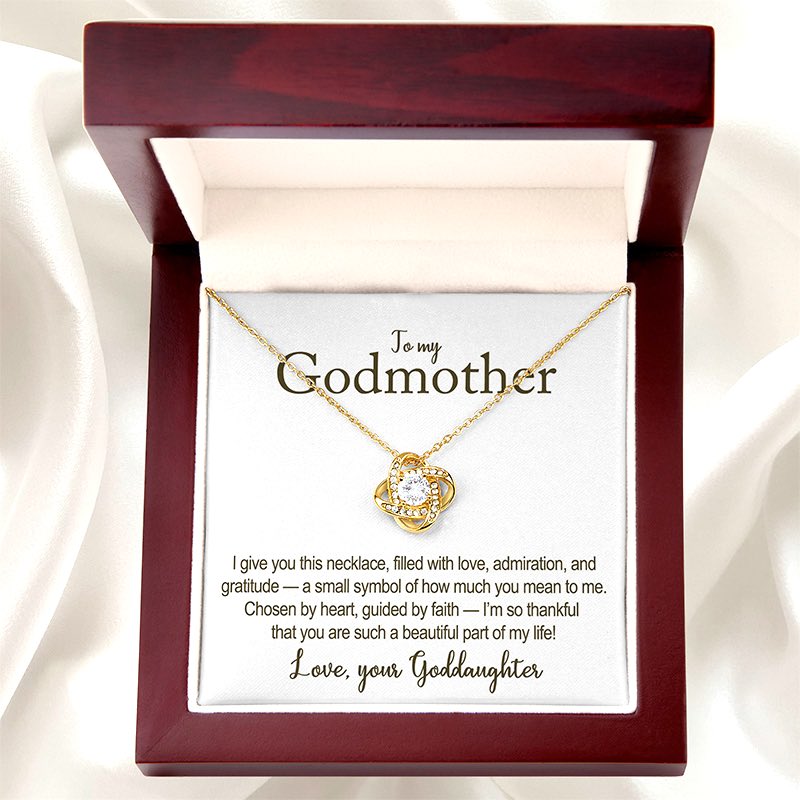 Gold necklace in a wooden box with a card for a godmother on a white background