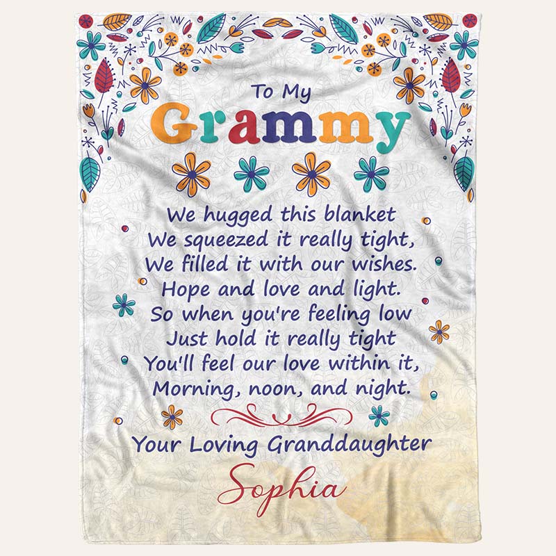 Fleece beige blanket with a floral border design, and a meaningful text to grandma from granddaughter, on a white background.