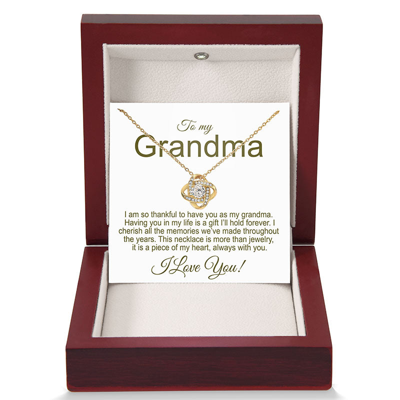 Gold necklace in a jewelry box with a card for a grandma